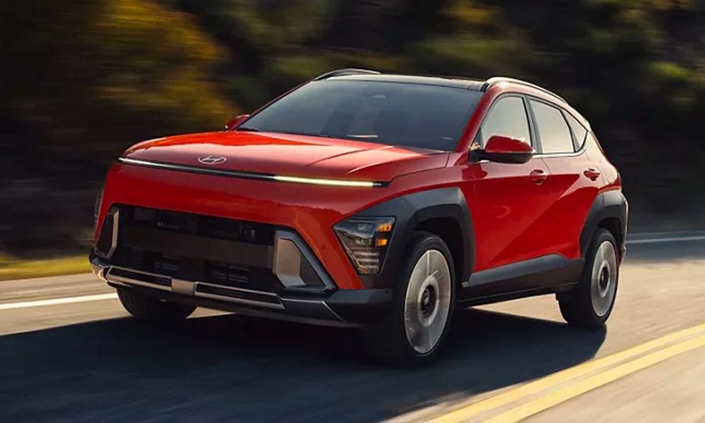 A bright red 2024 Hyundai Kona driving on the street